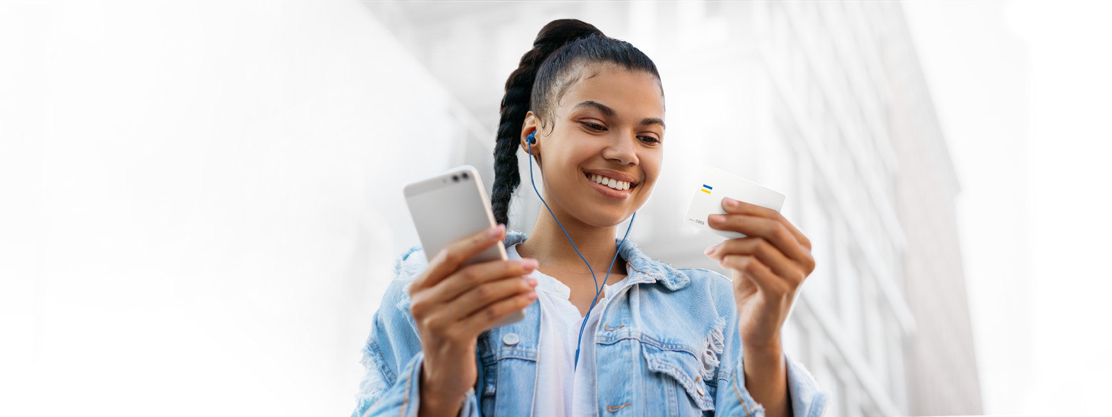 mujer sonriendo con su tarjeta de débito Visa en la mano