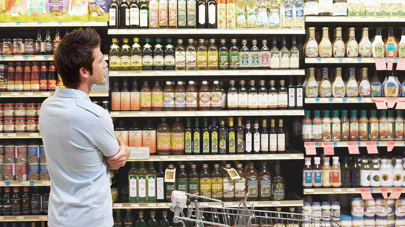 Hombre mirando góndola de supermercado