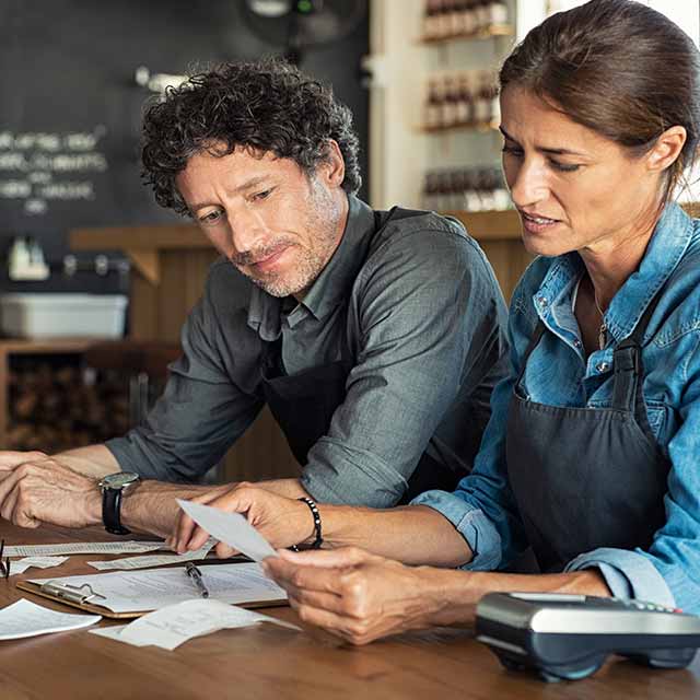 hombre y mujer revisando facturas de trabajo